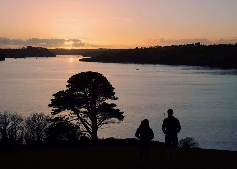 Silhouettes of students looking over the Fal estuary at sunset.