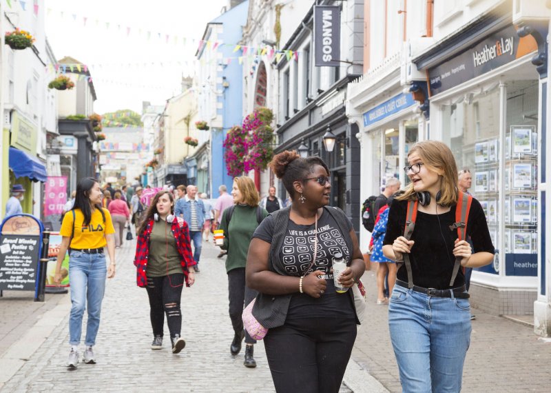 Group of students walking through Falmouth high street.