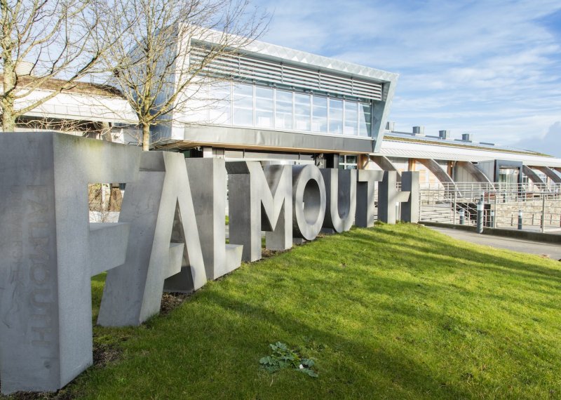 Falmouth University concrete sign in front of glass building