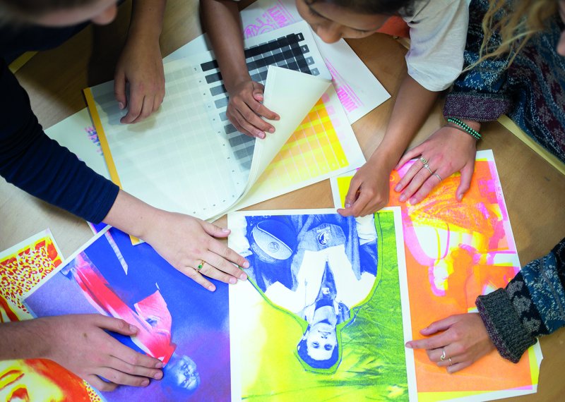 Aerial shot of Fashion Marketing students looking through images together 