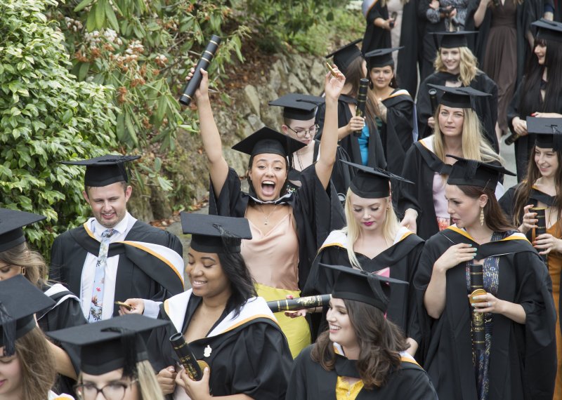 Falmouth University graduation 2019 – graduates walking through gardens in gowns and hats.