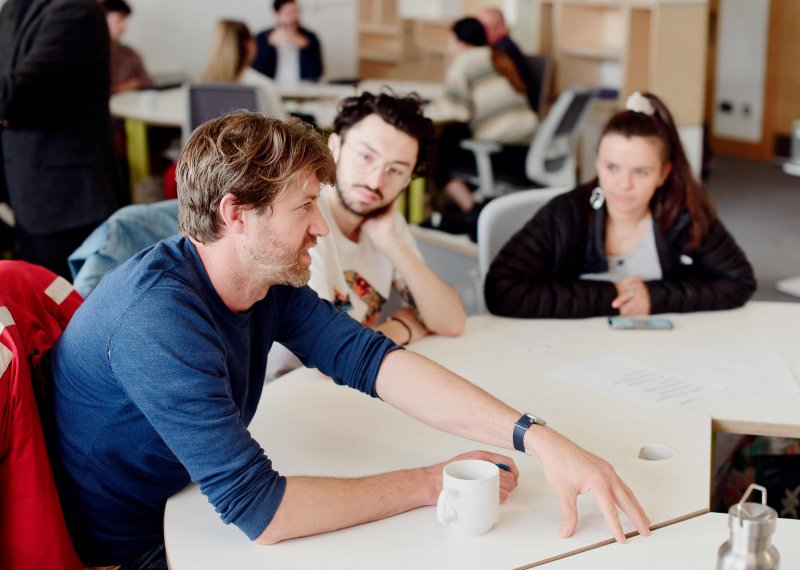 Staff and students talking around a table