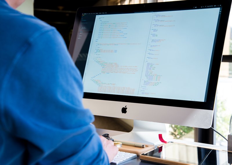 Student looking at code on an iMac.