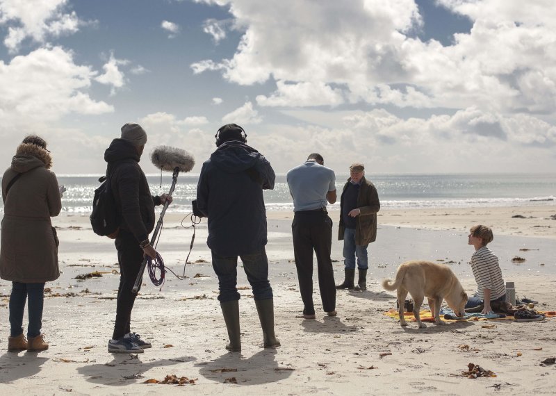 A group of student filming on a beach with sound equipment