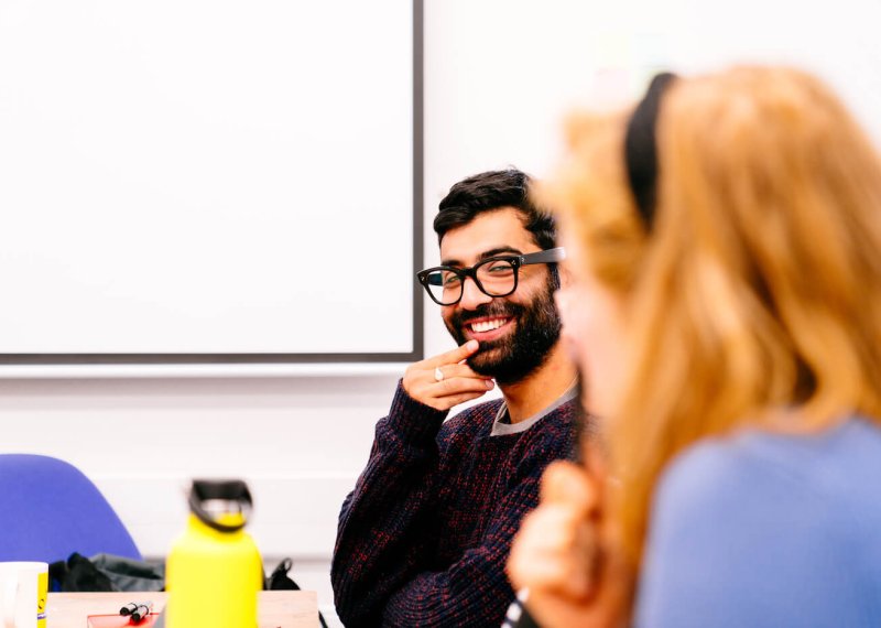 Two students sat together discussing Illustration