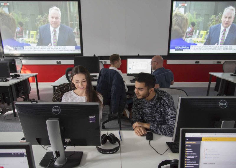 Two Falmouth University Journalism students working together at a computer