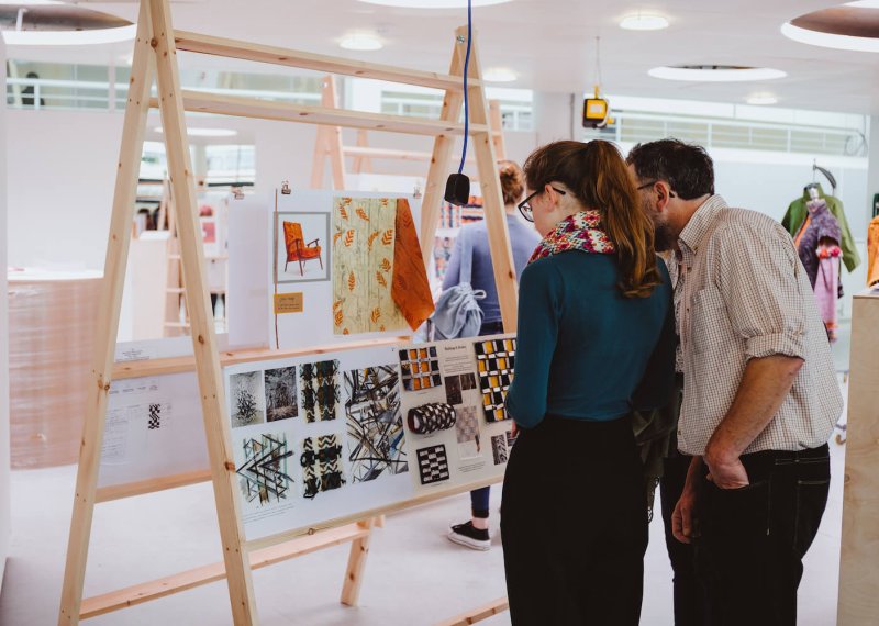 A father and daughter looking at an art exhibition at Falmouth University