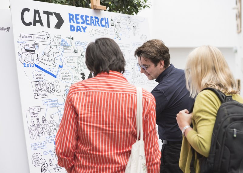 Two men and a woman at a whiteboard