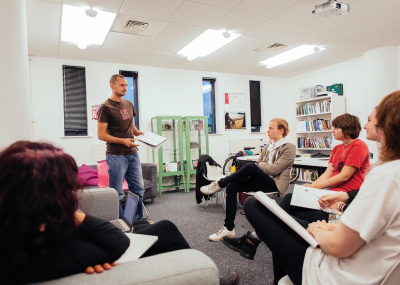 A Falmouth University student stood up presenting to other students in a seminar