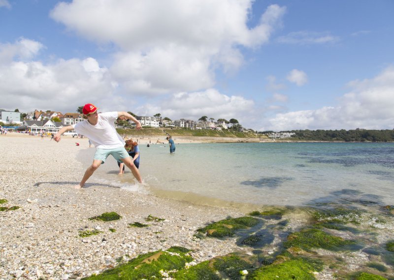Falmouth University students throwing stones on the shore