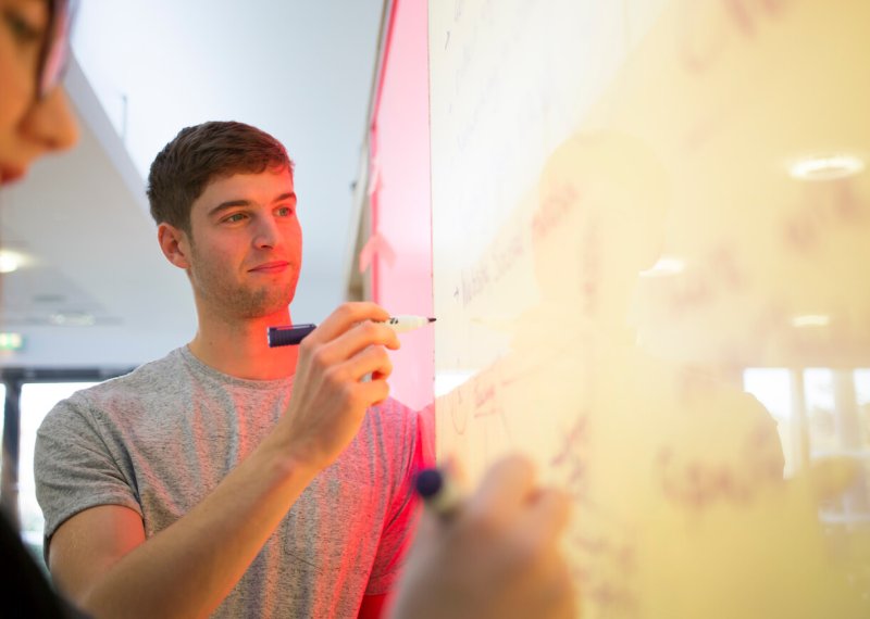 Falmouth University business student writing on a white board