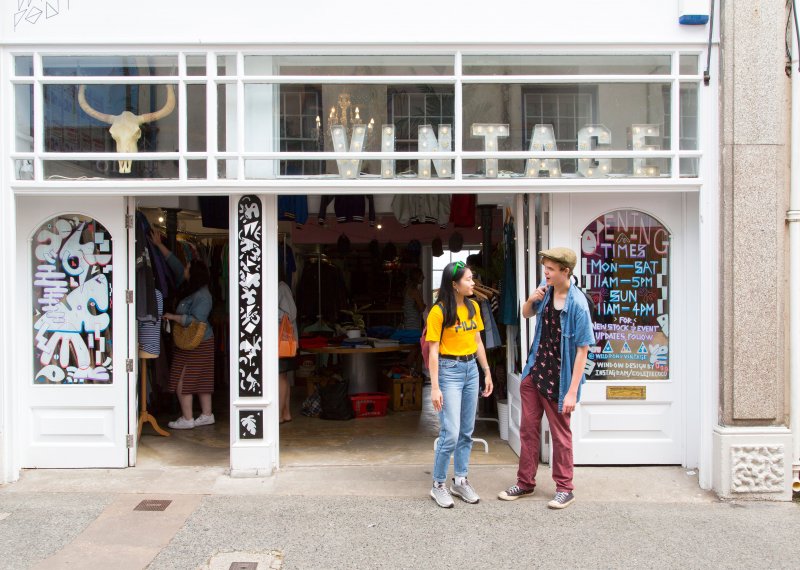 Students stood outside a shop with Vintage letter lights in the window.