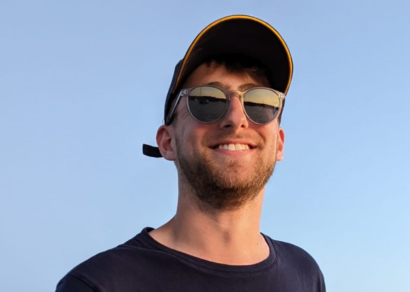 Man (Falmouth University graduate James Pearce) wearing black tshirt, sunglasses and cap