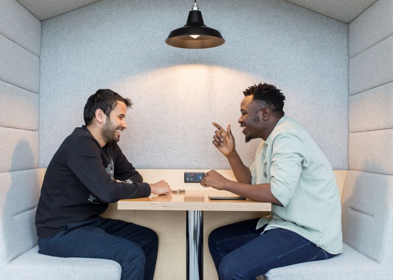 Two students talking across a table at Falmouth University