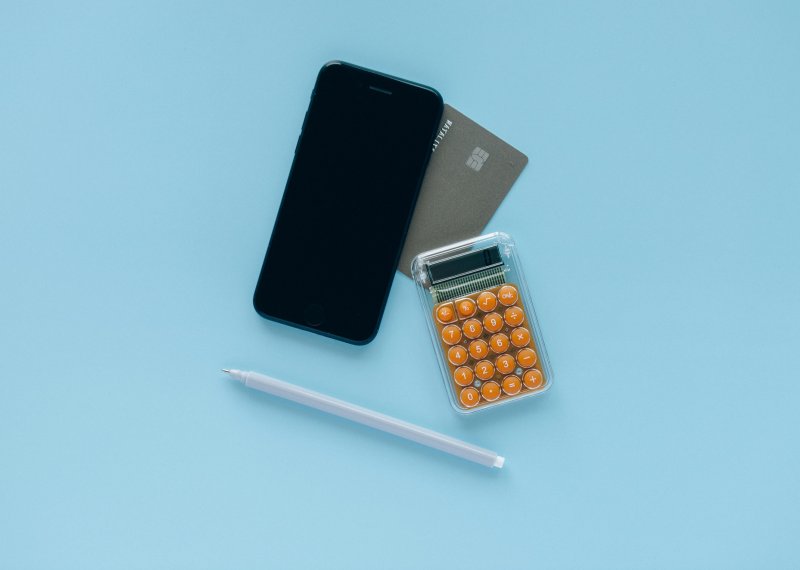 Phone, calculator and bank card on blue background