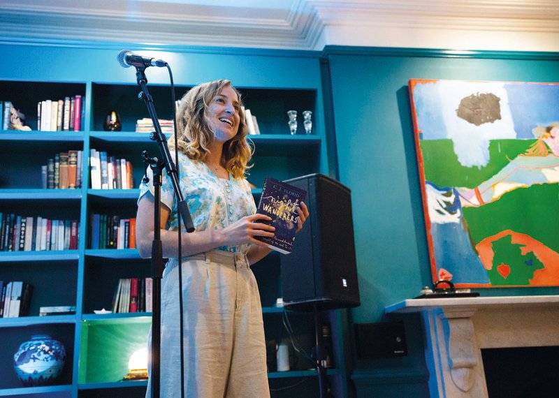 Student stood at microphone in front of bookcase