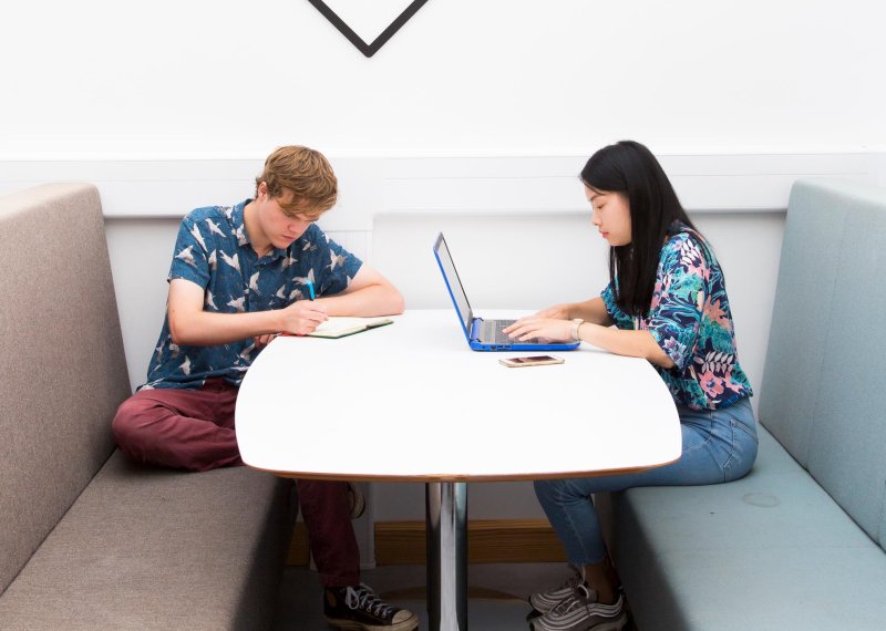 Two Falmouth University students working at a white table