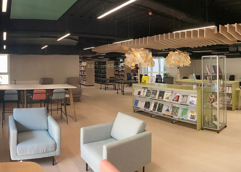 View of Falmouth University library with blue chairs and bookcases