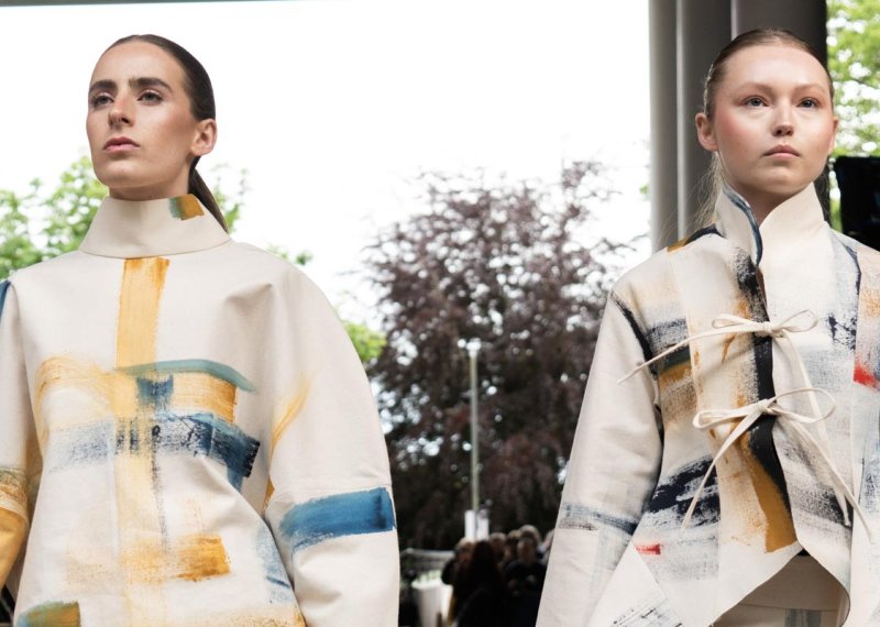 Two women wearing kimono style jackets at Falmouth University's 2024 graduate fashion show