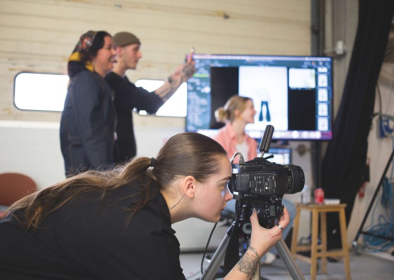Fashion photography student taking photo in studio