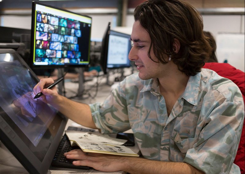 A male Game Art student from Falmouth University drawing on a digital screen