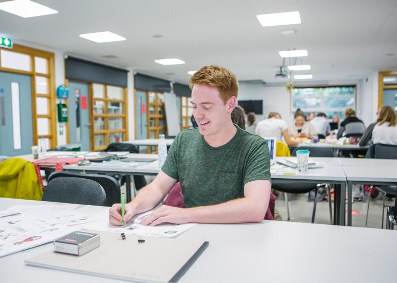 A male student in the Graphic Design studio at Falmouth University