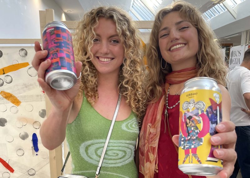 Two people holding Verdant beers with graphic designed labels