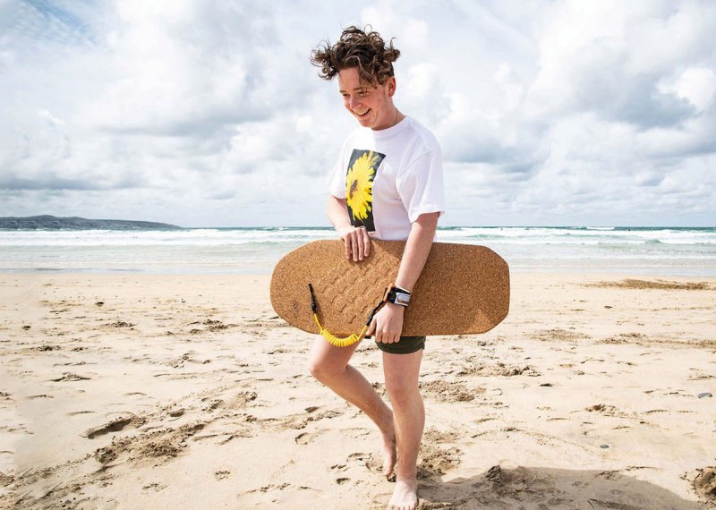 Model carrying cork bodyboard on beach