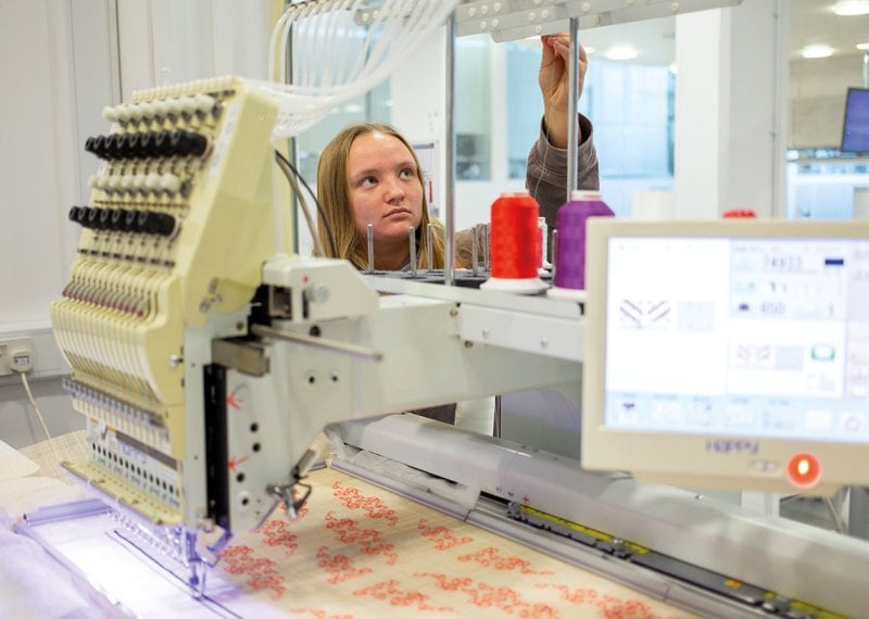 Textiles student working on machine
