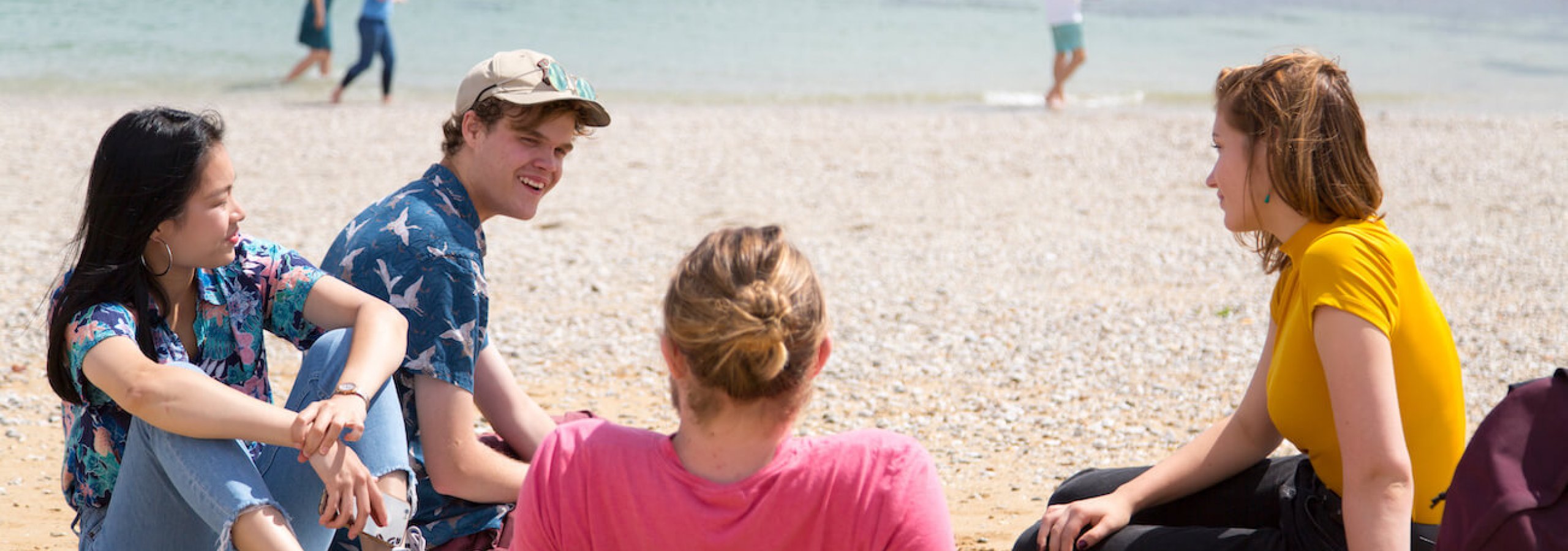 Falmouth University students relaxing on the beach