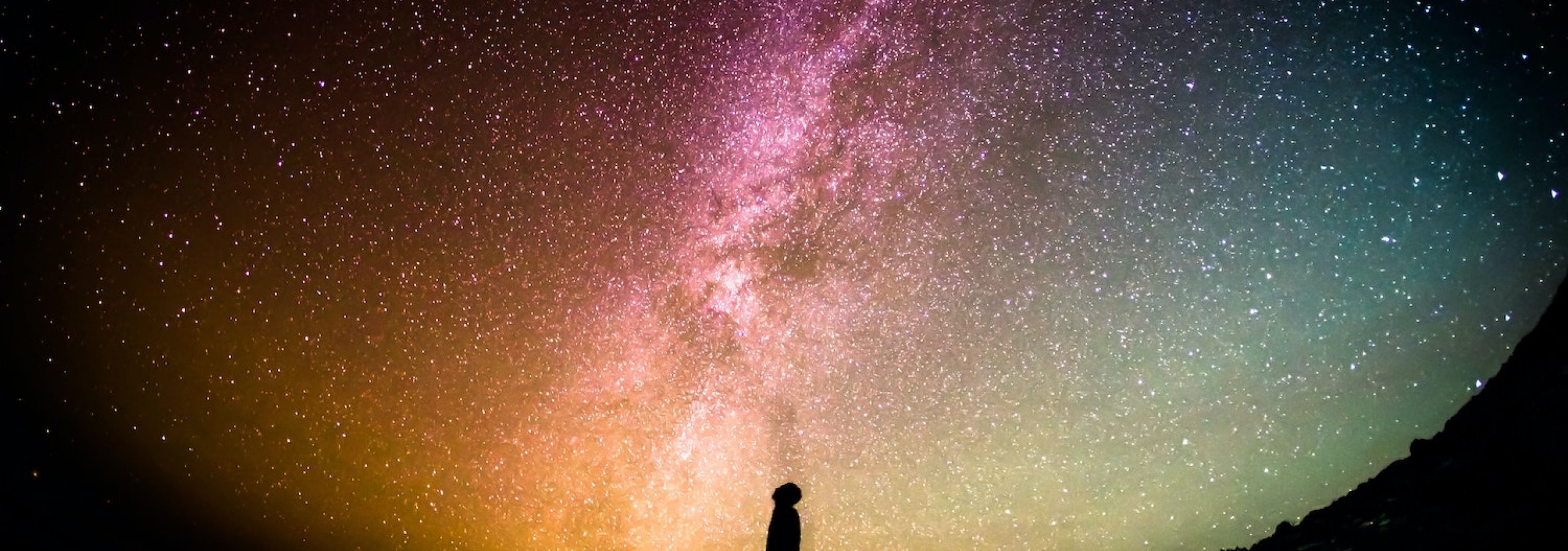 A silhouette in front of a sky of stars