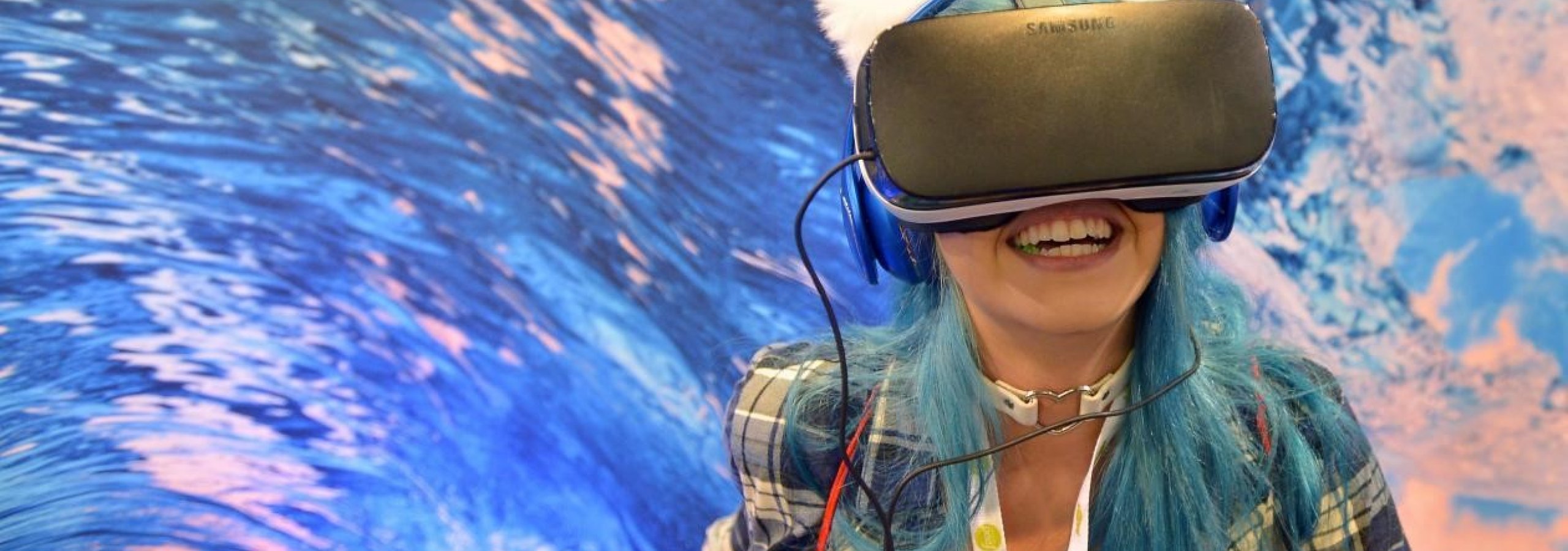 Girl wearing a VR headset in front of blue background