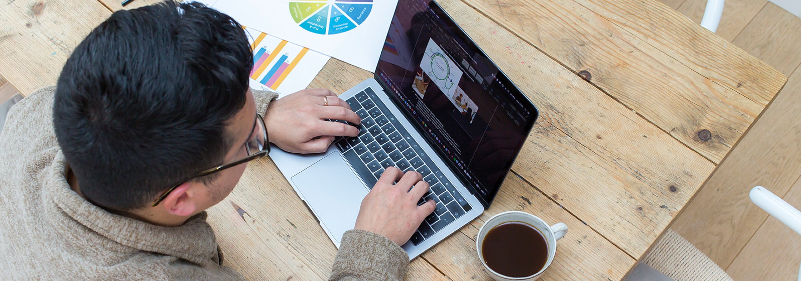 Person sat at a desk working on a laptop