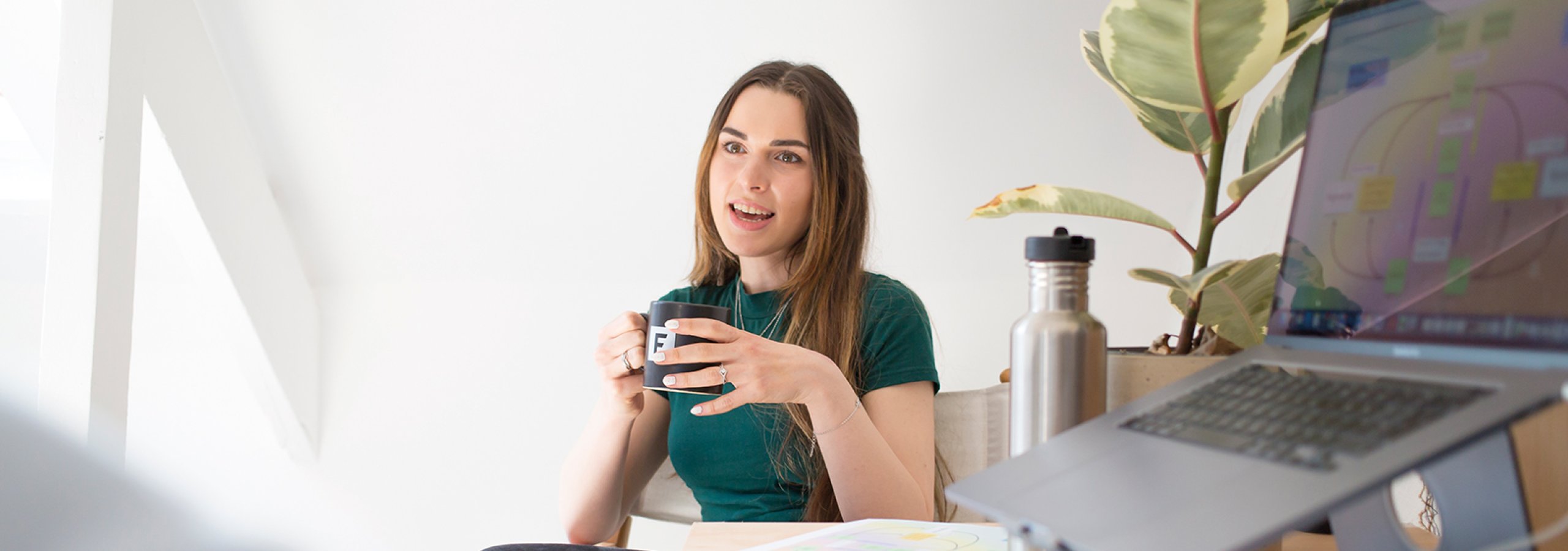 Person sat at table next to laptop talking