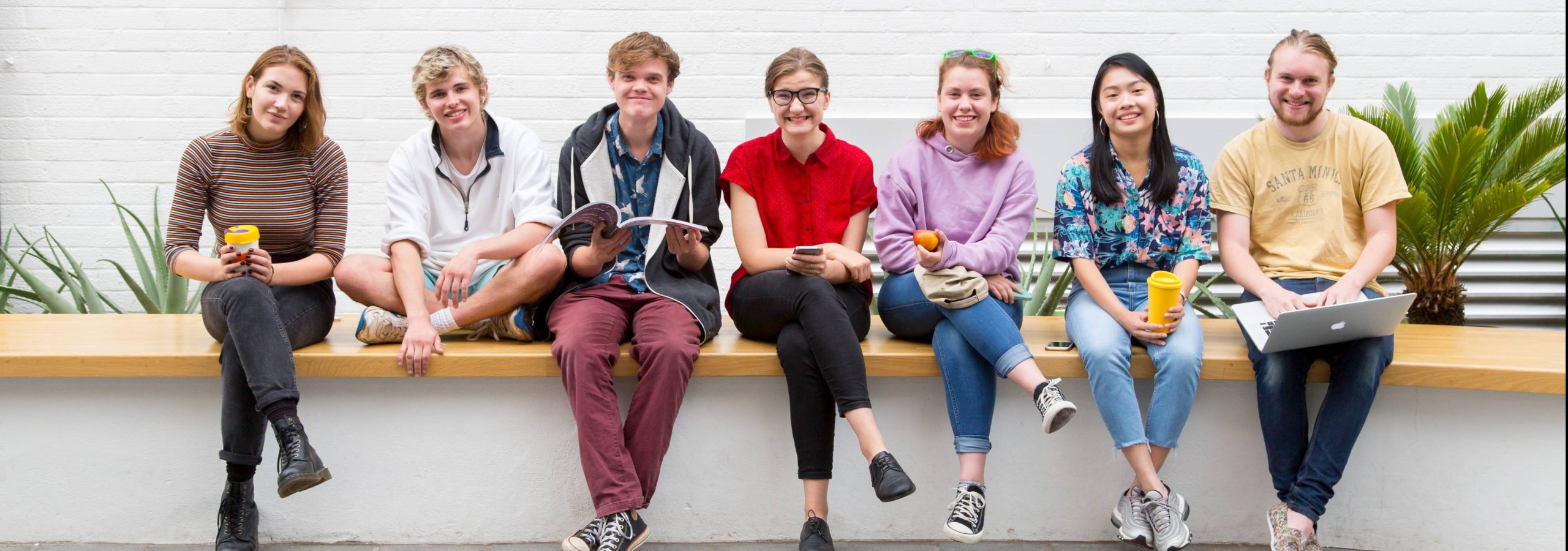 Students sitting on a wall