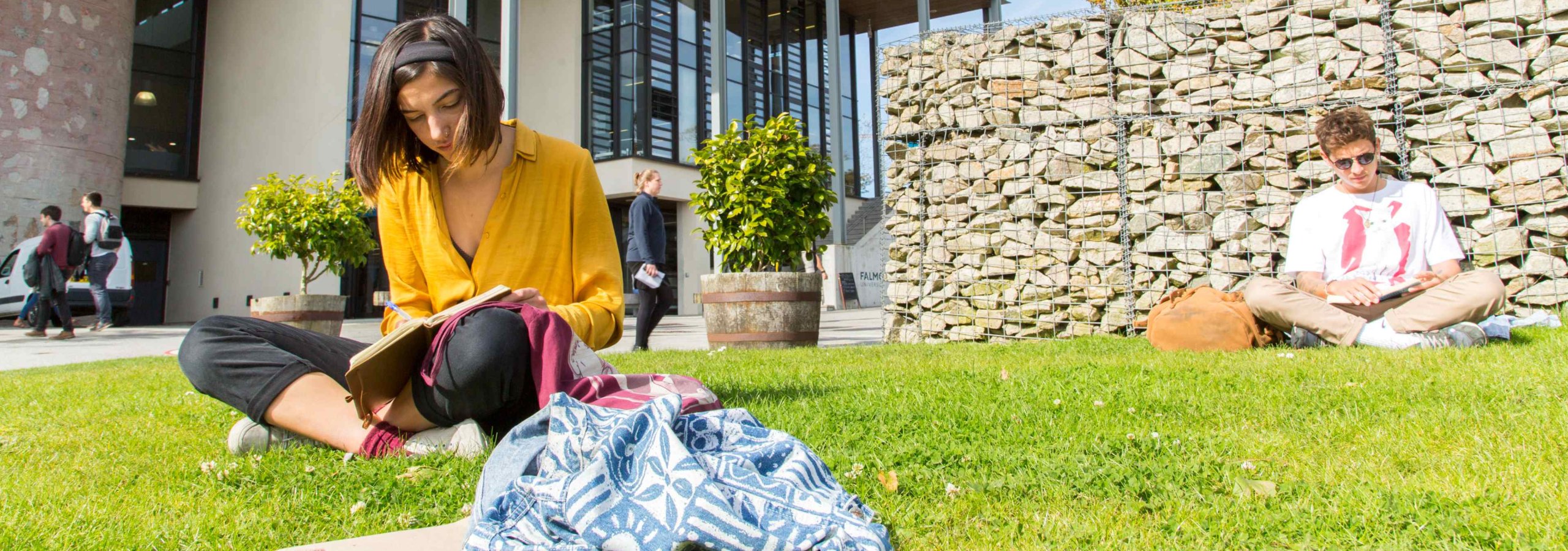 Students sit and read on the grass outside the Stannary
