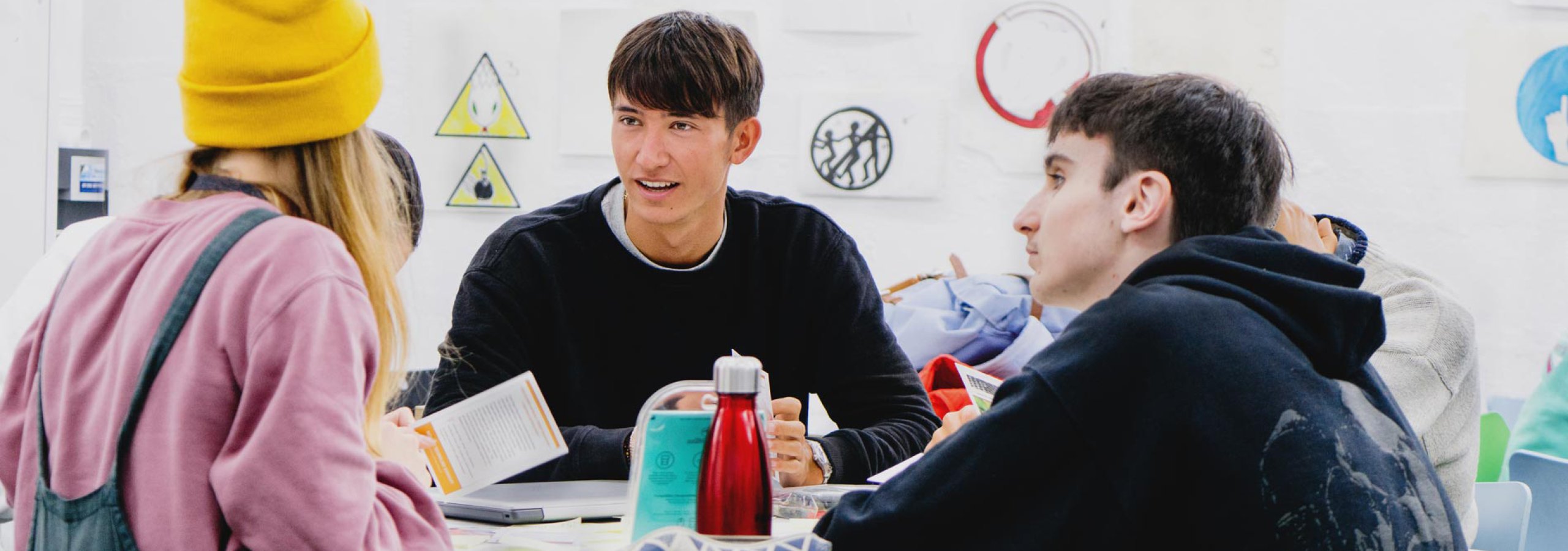 Three students gathered round a table at Falmouth University