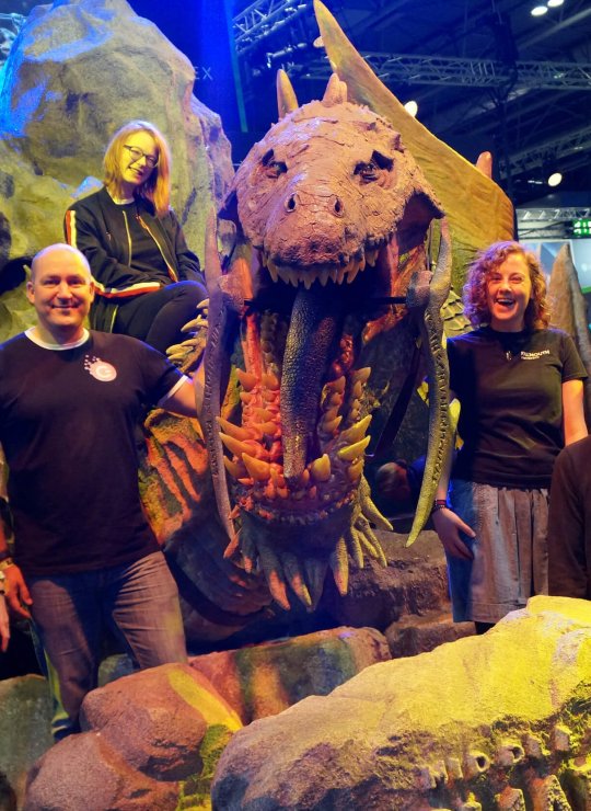 Falmouth University Games Academy students standing in front of a large dinosaur model