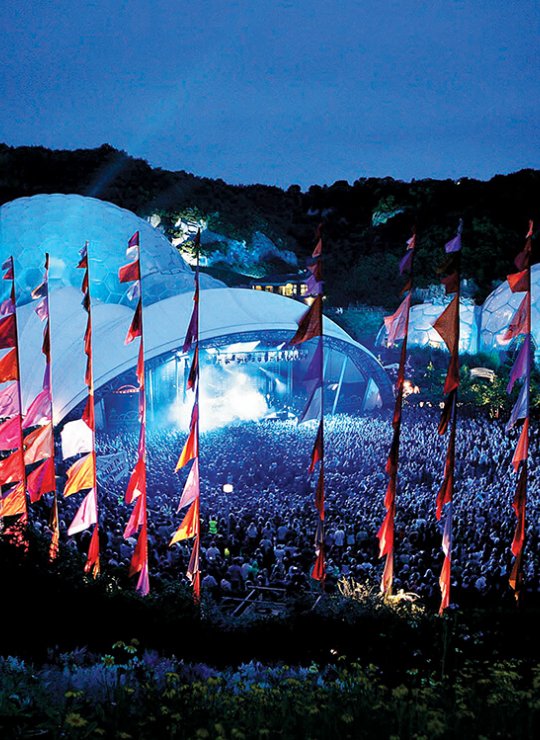 Music festival at the Eden Project with domes and pink flags