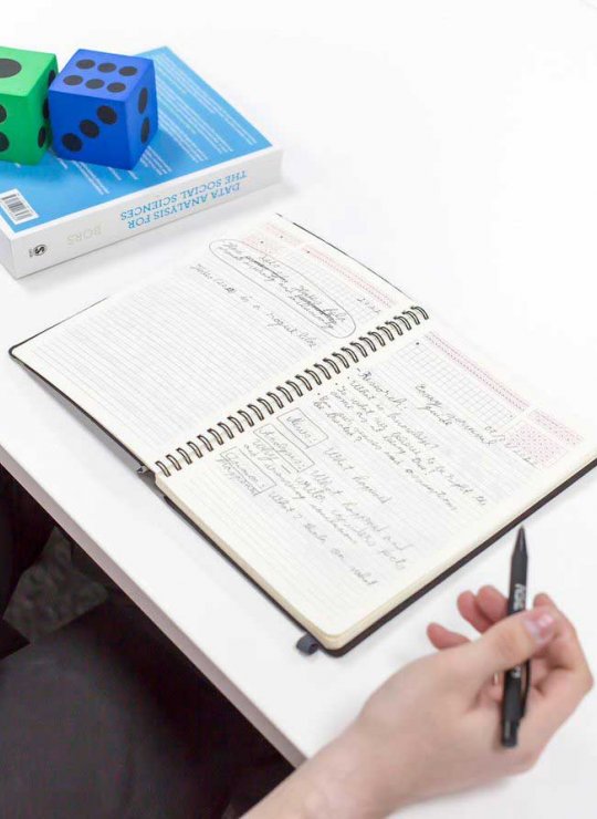 A student doing data calculations in a notebook
