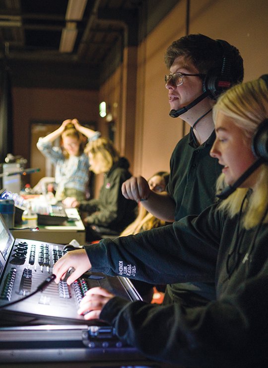 Two people sitting at a theatre tech desk working
