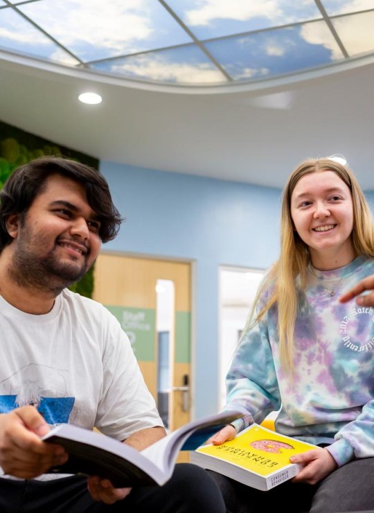 Three business students sat down, talking at Falmouth University