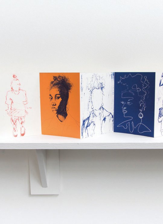 A fold out book of drawings on a shelf