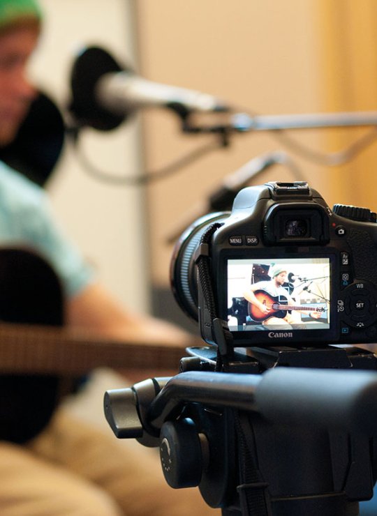 Camera shooting student playing guitar