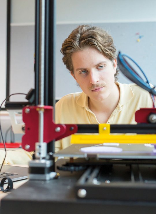 Student at desk working with robotic equipment