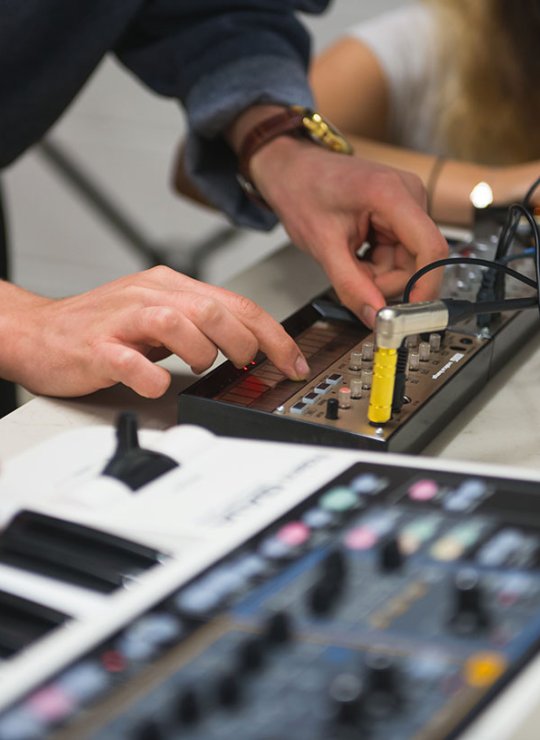 Close up of hands on keyboard and mixer