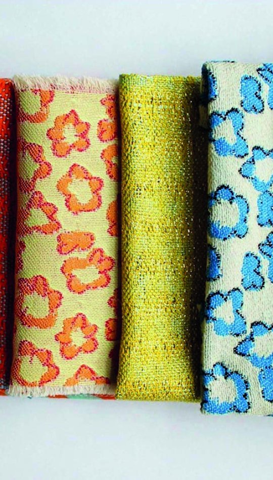 Six pieces of fabric lined up together with different patterns and textures