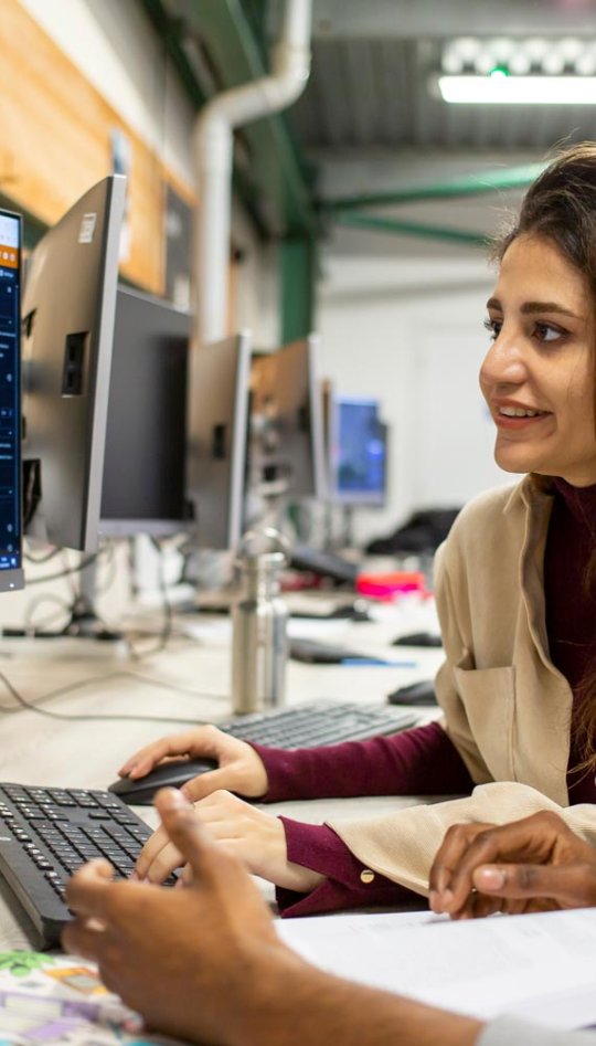 Two AI for Games students at a computer at Falmouth University