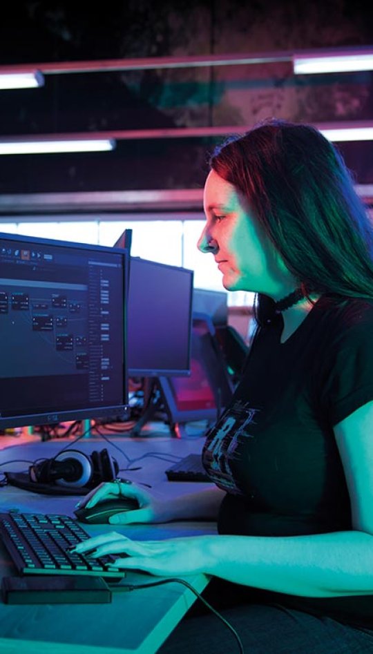 A female student working at a computer in Falmouth University's Games Academy