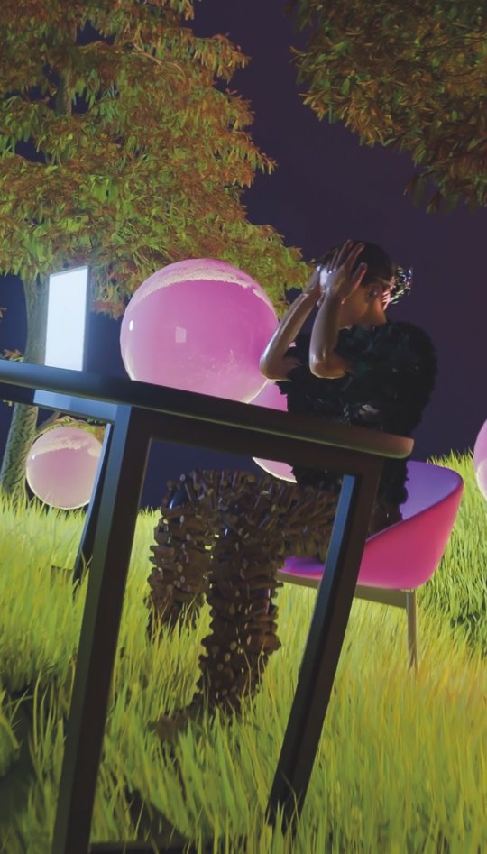 Person sat at table, grasping forehead surrounded by pink balls